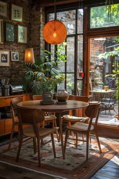 a dining room table and chairs in front of an open window with potted plants