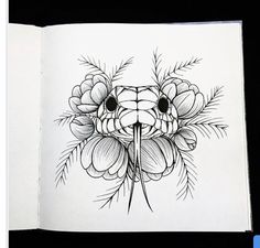 an open book with a drawing of flowers on the cover and a snake's head in the middle