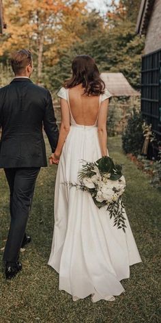 a bride and groom walking hand in hand