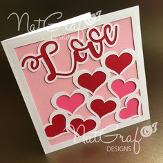 a pink card with hearts on it and the word love spelled in large red letters