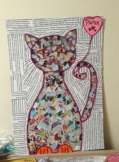 a cat made out of newspaper with a pink heart on it