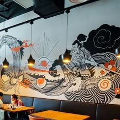 people sitting at tables in a restaurant with large murals on the wall and ceiling above them