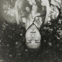 a person upside down in the grass with their head above his body and eyes closed