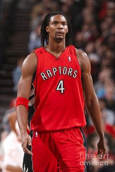 a basketball player with dreadlocks walking on the court in front of an audience