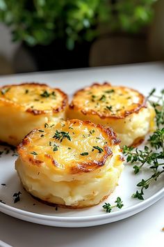 three potatoes on a white plate with herbs