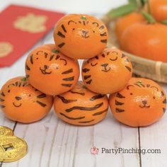 oranges with faces drawn on them sitting next to each other