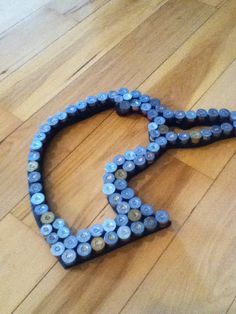 a pair of scissors made out of beer bottle caps on the floor in front of a wooden floor