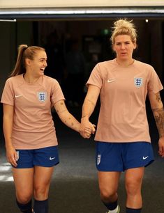 two female soccer players are holding hands