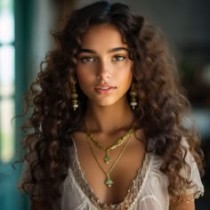 a beautiful young woman with long curly hair wearing gold necklaces and earrings on her neck