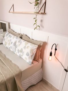 a bedroom with a bed, nightstand and plant hanging on the wall next to it