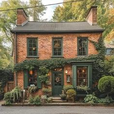 a brick house with green shutters and ivy growing on the front door is shown