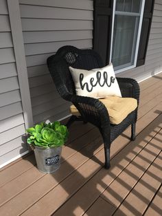 a chair with a pillow sitting on top of it next to a potted plant