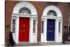 two red and blue doors in front of a brick building with white trimmings