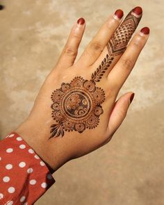 a woman's hand with henna tattoos on it