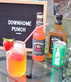 three different types of drinks sitting on a table next to a sign and strawberries