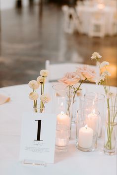 the table is set with candles and vases filled with flowers on top of it