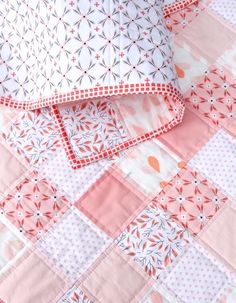 two pink and white quilts laying on top of each other