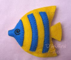 a small yellow and blue fish on a white surface