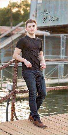 a young man is posing on a dock