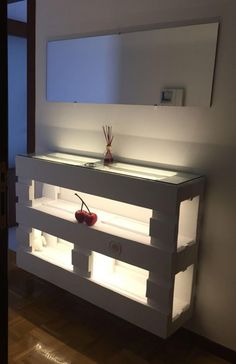 a bathroom vanity made out of pallets with lights on the side and an apple sitting on top