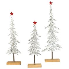 three metal christmas trees on wooden bases with red stars in the top, and one white fir tree