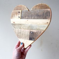 a heart shaped wooden cutting board with holes in it