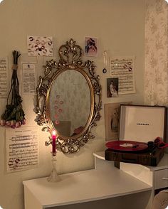 a mirror on the wall above a table with a candle and other items around it