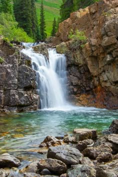 there is a waterfall in the middle of some rocks