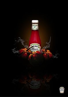 a bottle of ketchup sitting on top of apples with water splashing around it