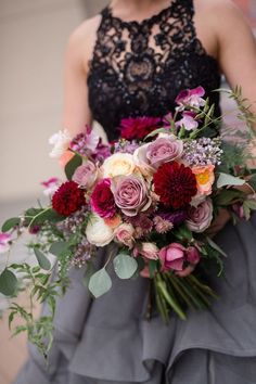 a woman holding a bouquet of flowers in her hands