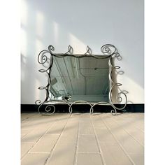 a mirror sitting on top of a tiled floor next to a wall