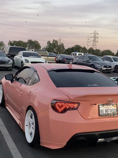 a pink sports car parked in a parking lot