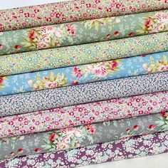 a stack of different colored fabrics with flowers on them