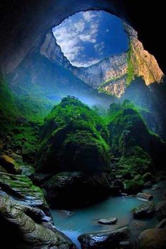 the inside of a cave with water and mountains