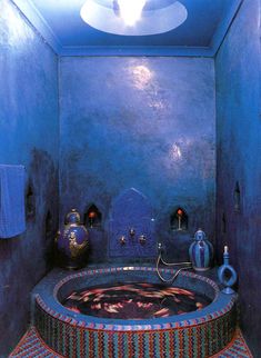 a blue bathroom with a round tub in the middle