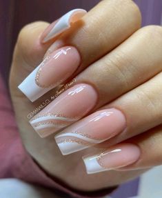 a woman's hand with some pink and white nail polishes on her nails