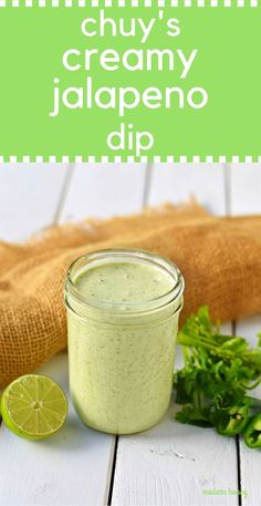 a jar filled with creamy jalapeno dip on top of a wooden table