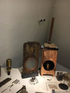 an old fashioned speaker sitting on top of a table next to other antique items and tools