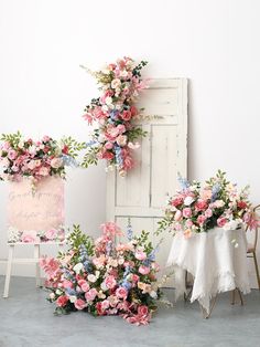 pink and blue flowers are arranged in front of a white door with a sign that says congratulations