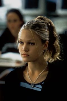 the young woman is sitting at her desk in front of two other women behind her