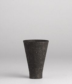 a black vase sitting on top of a white table