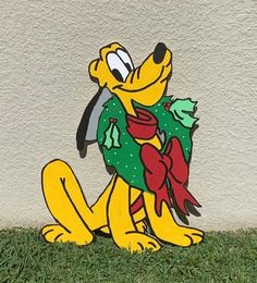 a cartoon dog sitting on the grass holding a wreath