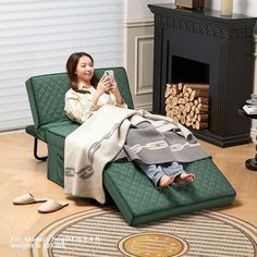 a woman laying on a green reclining chair with a blanket over her head while holding a cell phone