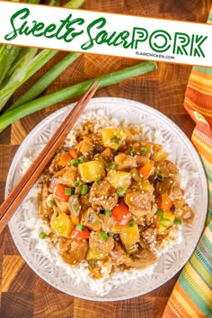 a white plate topped with meat and vegetables next to chopsticks