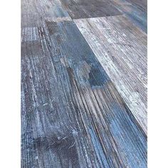 an old wooden floor with blue and white paint on it's surface is seen in this image