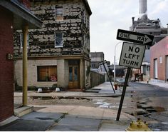 a one way no left turn sign in front of an old brick building and fire hydrant