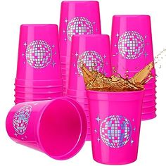 pink plastic cups with disco balls and stars on them, one is filled with gold