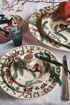 two plates with christmas decorations on them and silverware