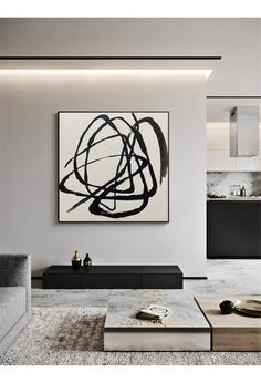 a modern living room with black and white art on the wall above the coffee table