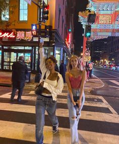 two young women crossing the street at night